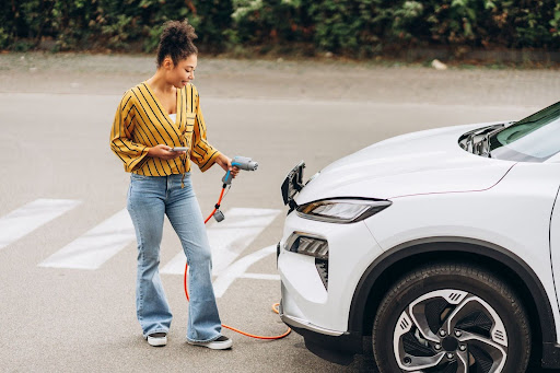 Mulher recarregando bateria de carro elétrico