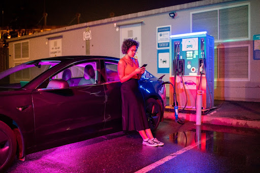 Mulher em posto de carregamento de carros elétricos
